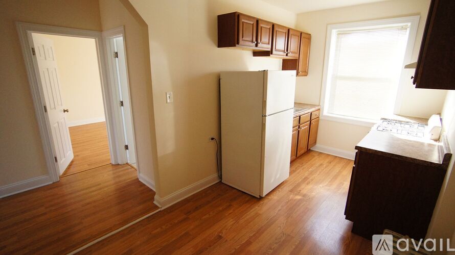 A kitchen with a white fridge and wooden cabinets.