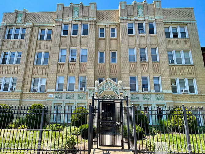 A large building with a black gate in front.