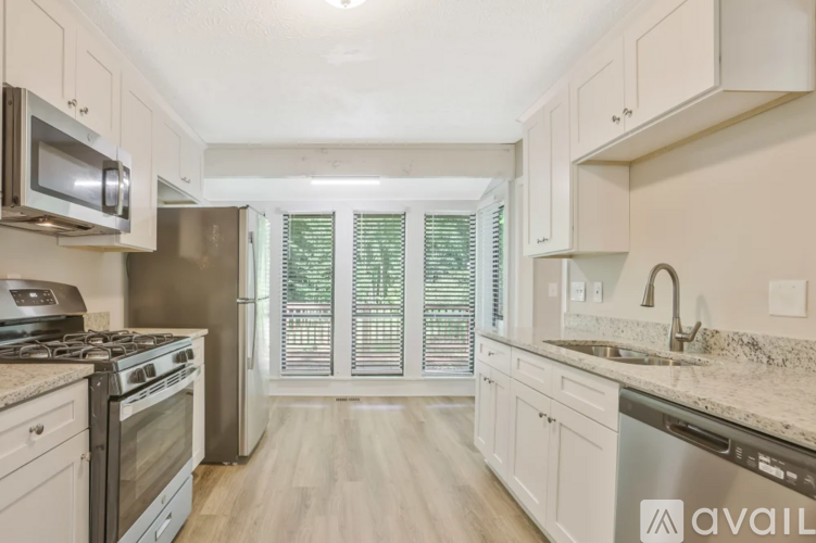 A kitchen with white cabinets and a granite countertop.