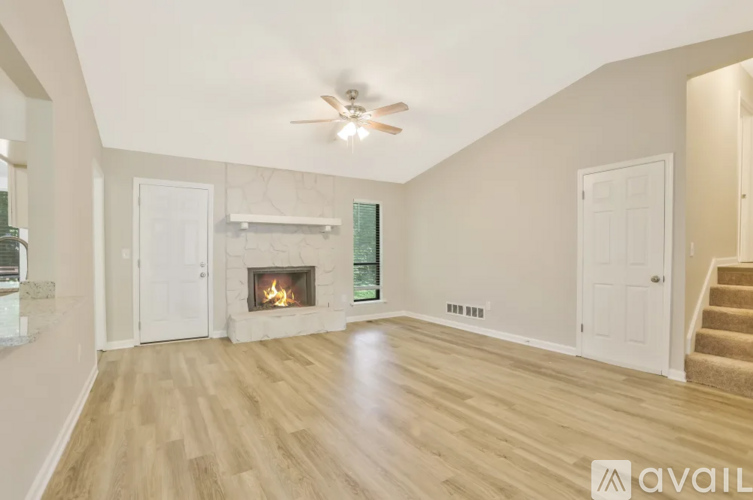 A spacious room with a fireplace and a ceiling fan.