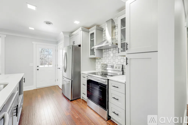 A modern kitchen with white cabinets and stainless steel appliances.