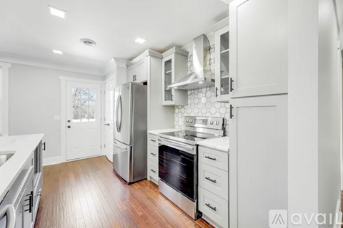 A modern kitchen with white cabinets and stainless steel appliances.