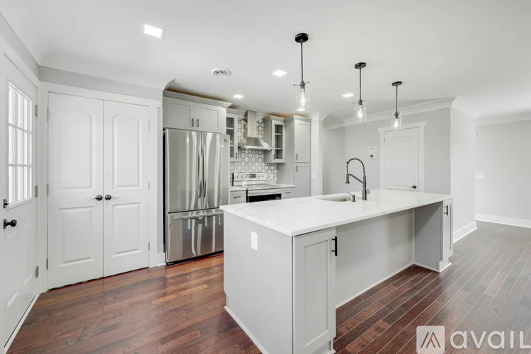 A kitchen with white cabinets and a wooden floor.