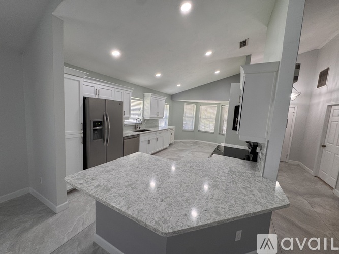 A kitchen with a granite countertop and a refrigerator.