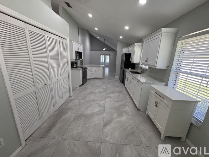 A spacious kitchen with white cabinets and a central island.