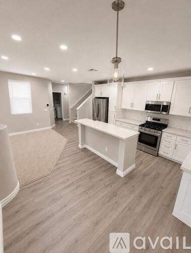 A modern kitchen with white cabinets and a central island.