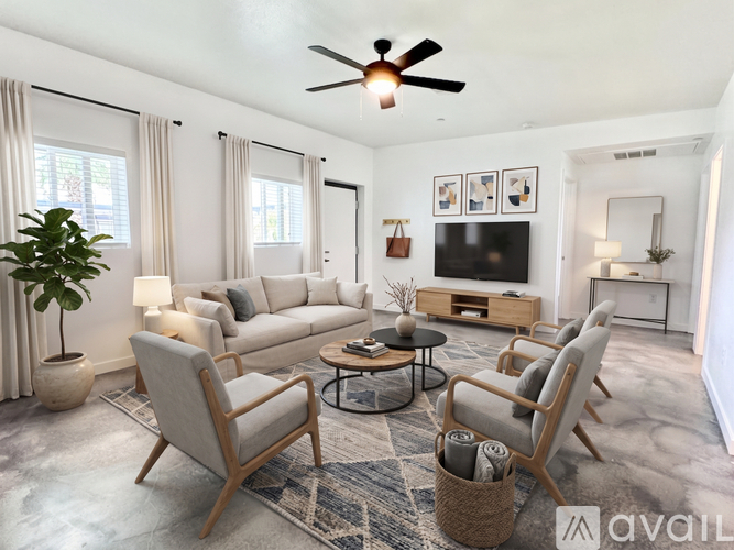 A living room with a grey sofa, a wooden coffee table, and a ceiling fan.