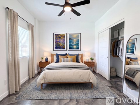 A bedroom with a large bed and a ceiling fan.