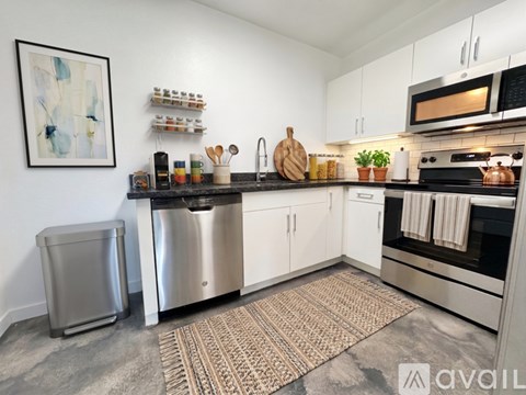 A kitchen with white cabinets and a stainless steel dishwasher.