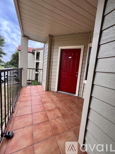 A red door is on the right side of a balcony.