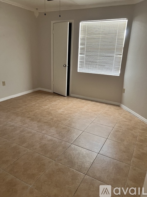A room with a tiled floor and a door leading to another room.