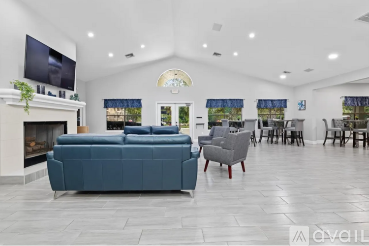 A living room with a blue couch and a fireplace.