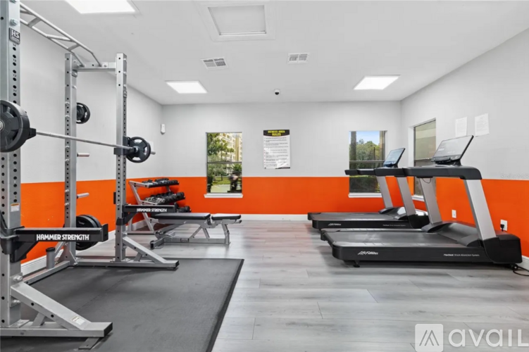 A gym with orange walls and a variety of equipment.