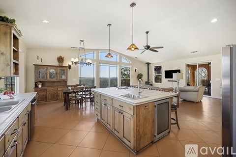 A kitchen with wooden cabinets and a large island with a sink.