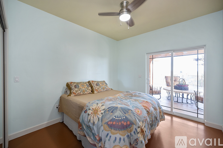 A bedroom with a bed and a ceiling fan.