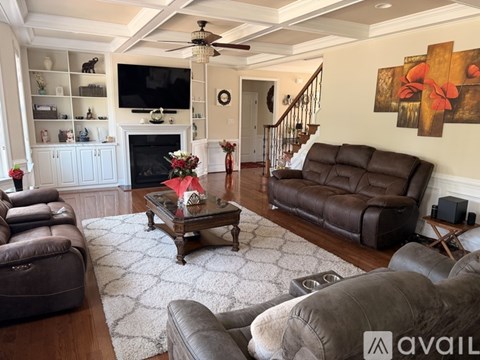 A living room with brown leather furniture and a white fireplace.