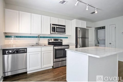 A kitchen with white cabinets and stainless steel appliances.