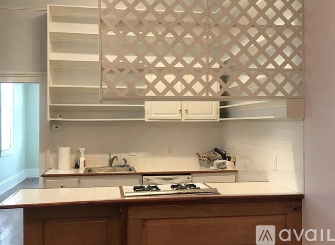 A kitchen with a wooden counter and a white backsplash.