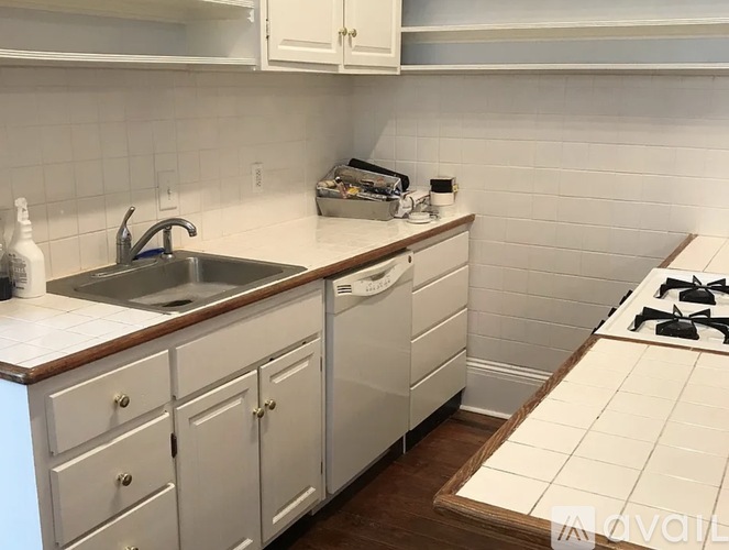 A kitchen with white cabinets and a white stove top.