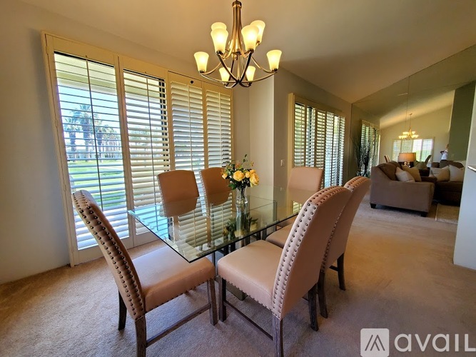 A dining room with a glass table and chairs.