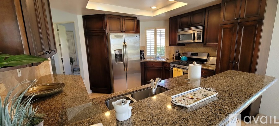 A kitchen with granite countertops and stainless steel appliances.
