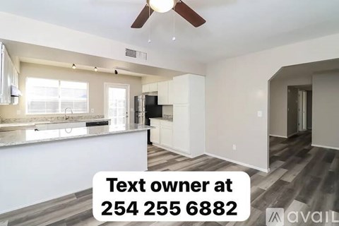 A modern kitchen with a text box on the image offering contact information for the owner.