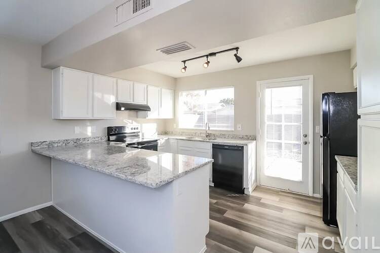 A kitchen with a marble countertop and white cabinets.
