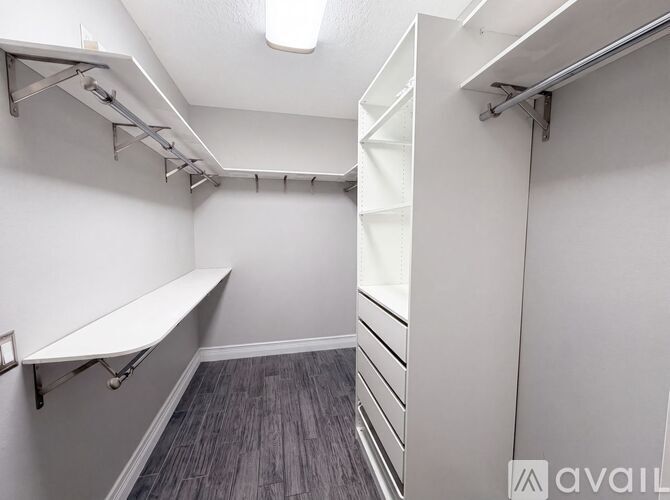 A white bench is in a room with a grey floor and white walls.