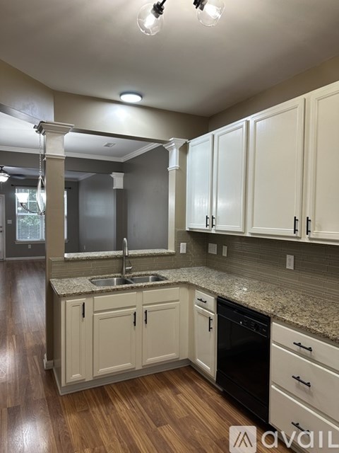 A kitchen with white cabinets and a granite countertop.