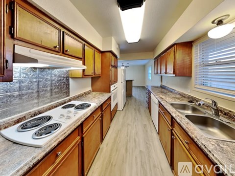 A kitchen with wooden cabinets and a white stove top.