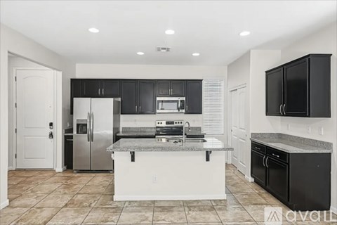 A modern kitchen with black cabinets and stainless steel appliances.