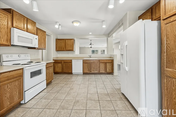 A kitchen with white appliances and wooden cabinets.