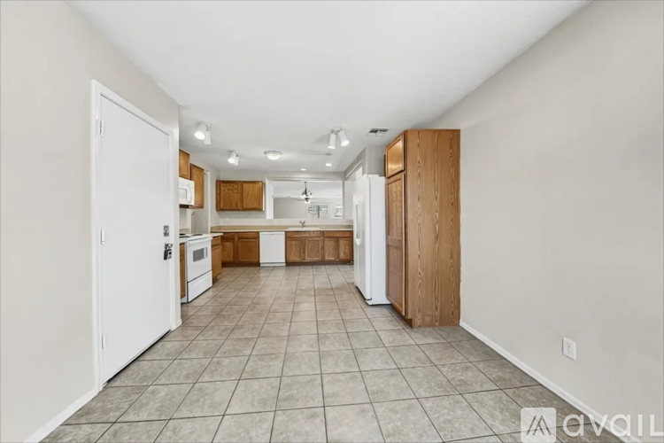 A kitchen with white appliances and wooden cabinets.