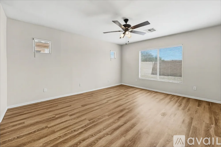 A room with wooden flooring and a ceiling fan.