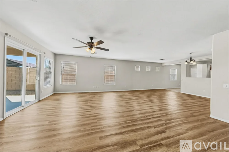 A spacious room with wooden flooring and a ceiling fan.