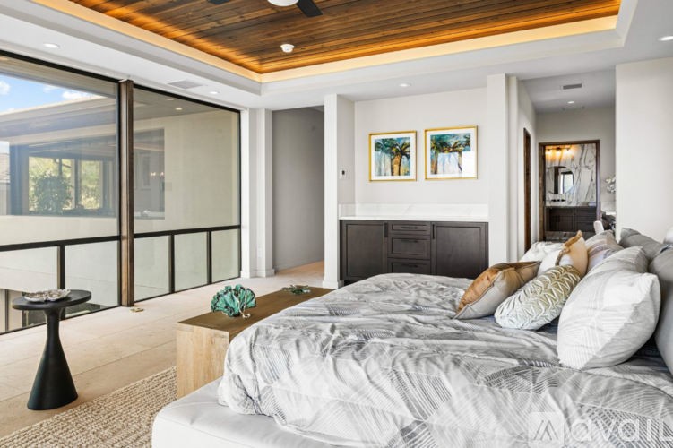 A bedroom with a large bed and a balcony.