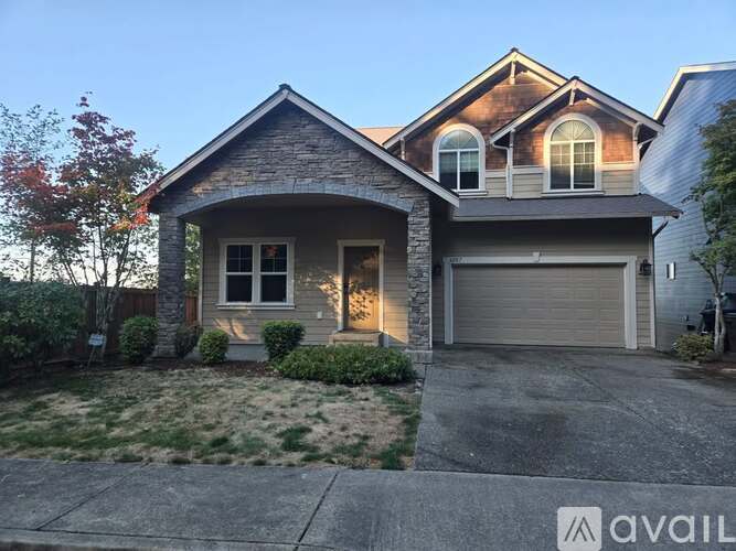 A house with a garage and a driveway in front.