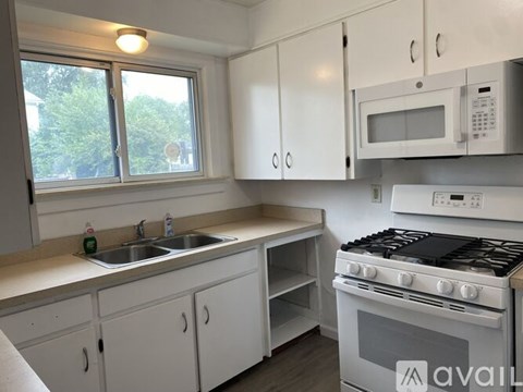A kitchen with white cabinets and a stove top oven.