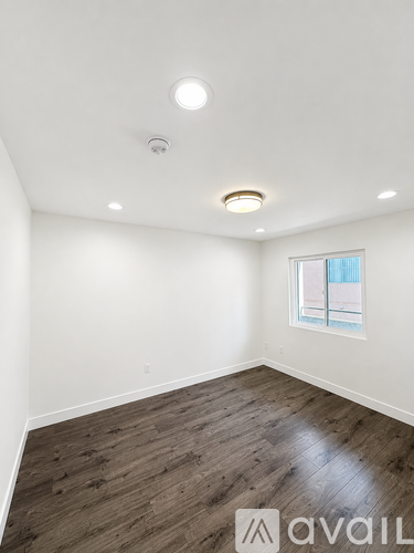A room with wooden flooring and a window.