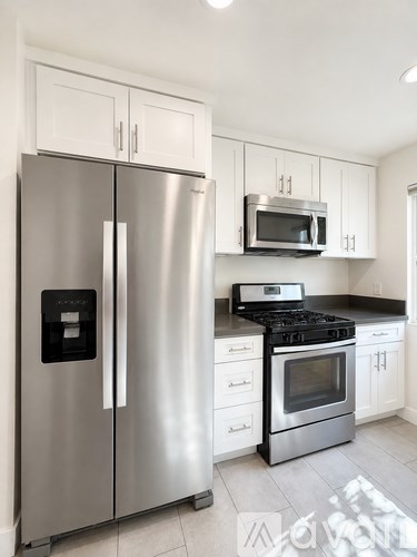 A modern kitchen with a stainless steel refrigerator and microwave.