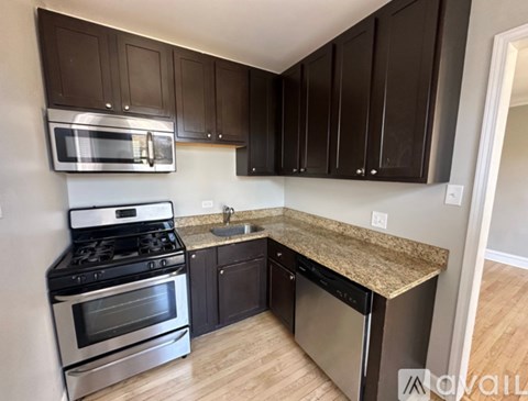A kitchen with dark brown cabinets and stainless steel appliances.