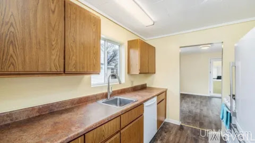 A kitchen with wooden cabinets and a white dishwasher.