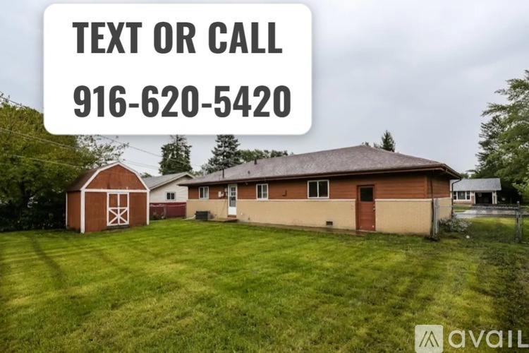 A house with a barn and a grassy yard is for sale.