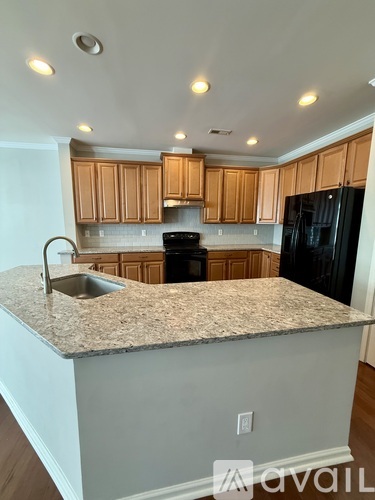 A kitchen with wooden cabinets and a granite countertop.