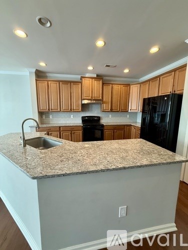 A kitchen with wooden cabinets and a granite countertop.
