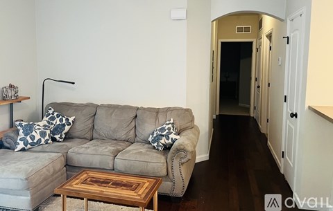 A living room with a grey couch and a wooden coffee table.