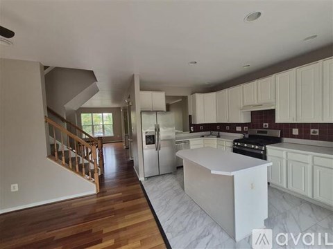 A kitchen with white cabinets and a wooden floor.