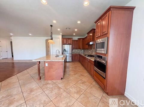A kitchen with wooden cabinets and a tiled floor.