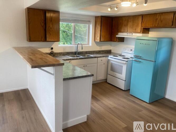 A kitchen with a blue fridge and wooden cabinets.