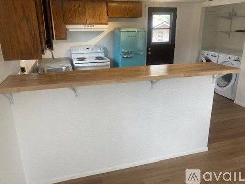 A kitchen with a white stove and a blue refrigerator.